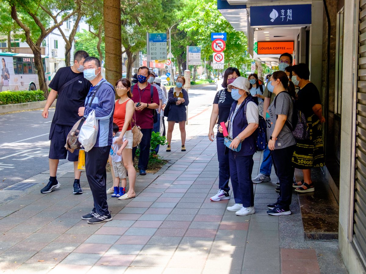 台北市三民路公車站牌前，數名民眾站在站牌旁等候公車
