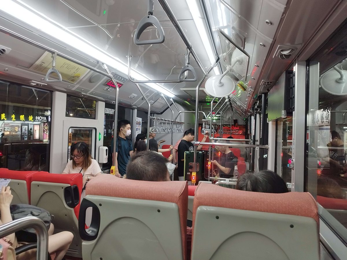 台北市 284 路公車車廂內部，乘客坐在紅色座椅上